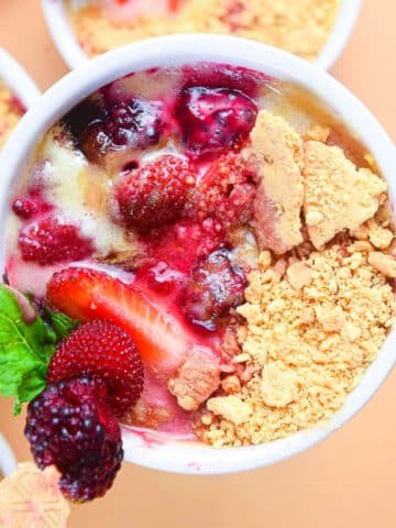 Berries and cream in a ramekin.