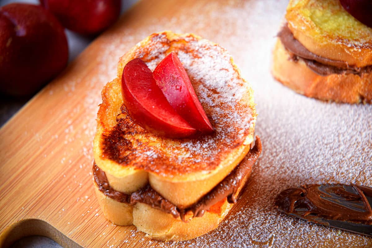 French toast stuffed with Nutella on cutting board.
