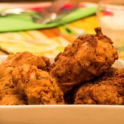 Electric skillet fried chicken in a dish.
