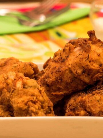 Electric skillet fried chicken in a dish.