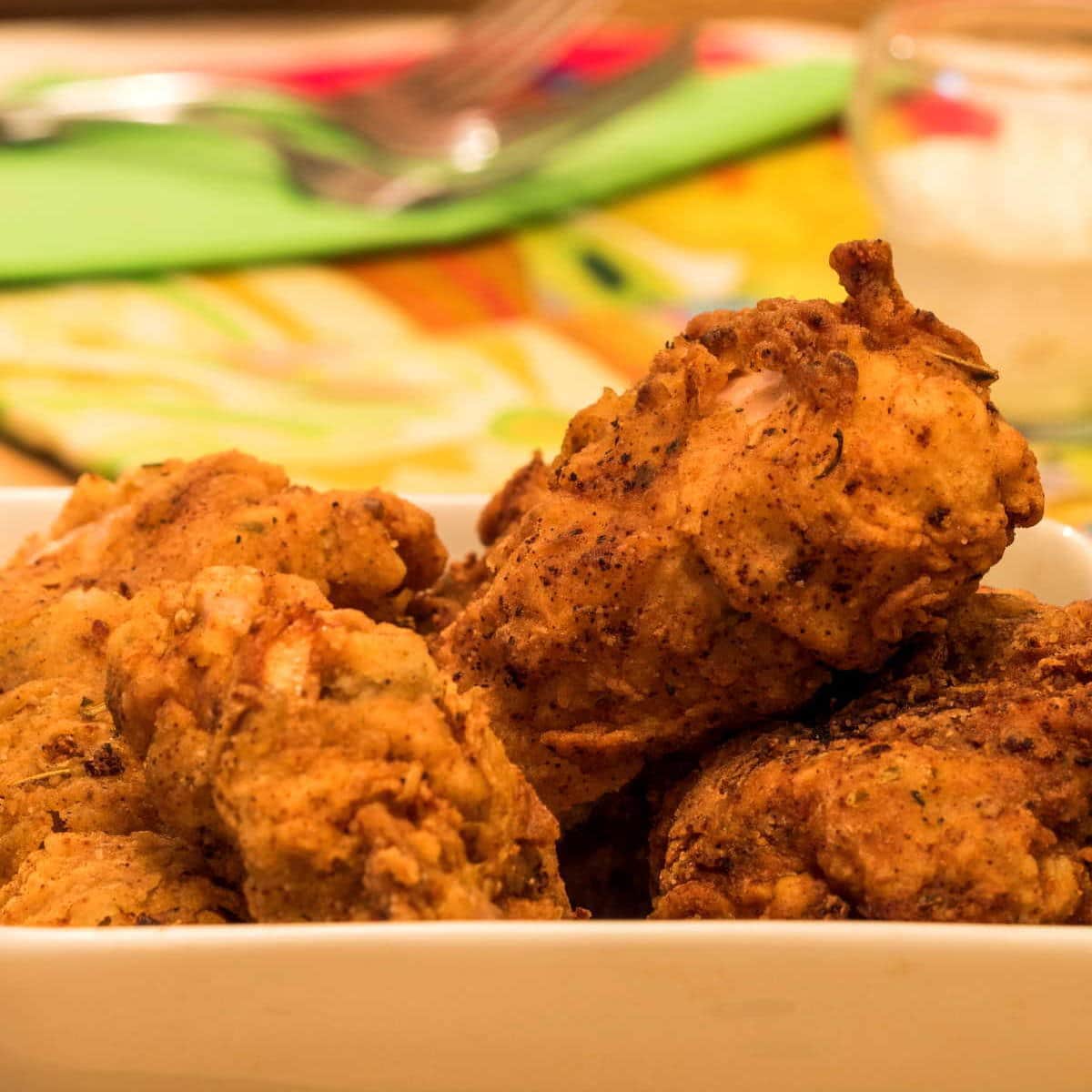 Electric skillet fried chicken in a dish.