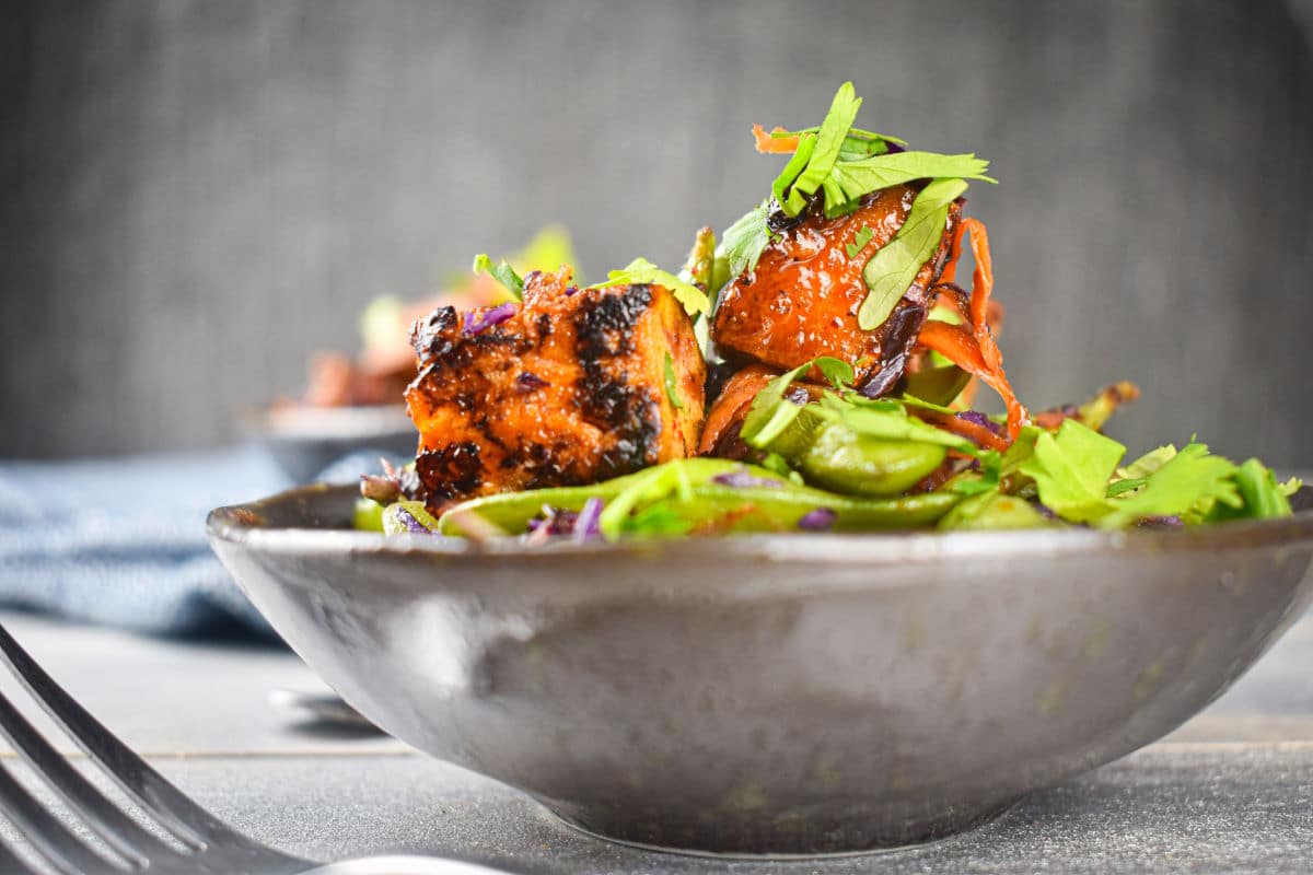 Fried tofu with snap peas in bowl.