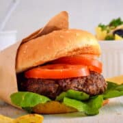 Electric Skillet Hamburgers on wooden background with salad on the side.
