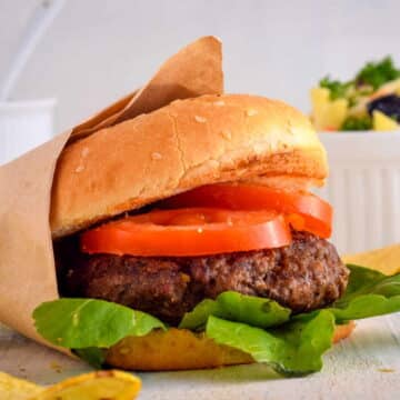 Electric Skillet Hamburgers on wooden background with salad on the side.
