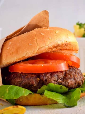 Electric Skillet Hamburgers on wooden background with salad on the side.