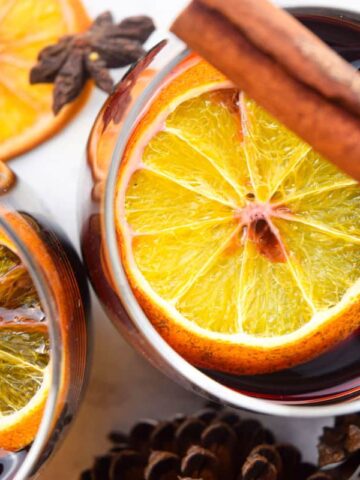 Top view of mulled wine with orange slices and cinnamon sticks.