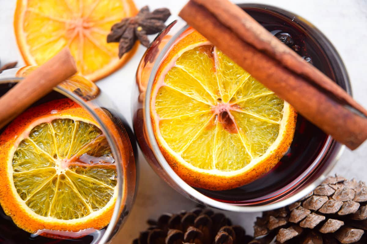 Top view of mulled wine with orange slices and cinnamon sticks.