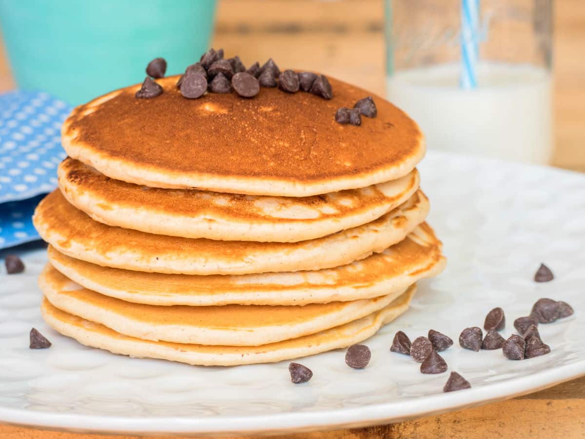 Electric Skillet Pancakes 1 - IntheKitch Pancakes piled on a plate with chocolate chips.