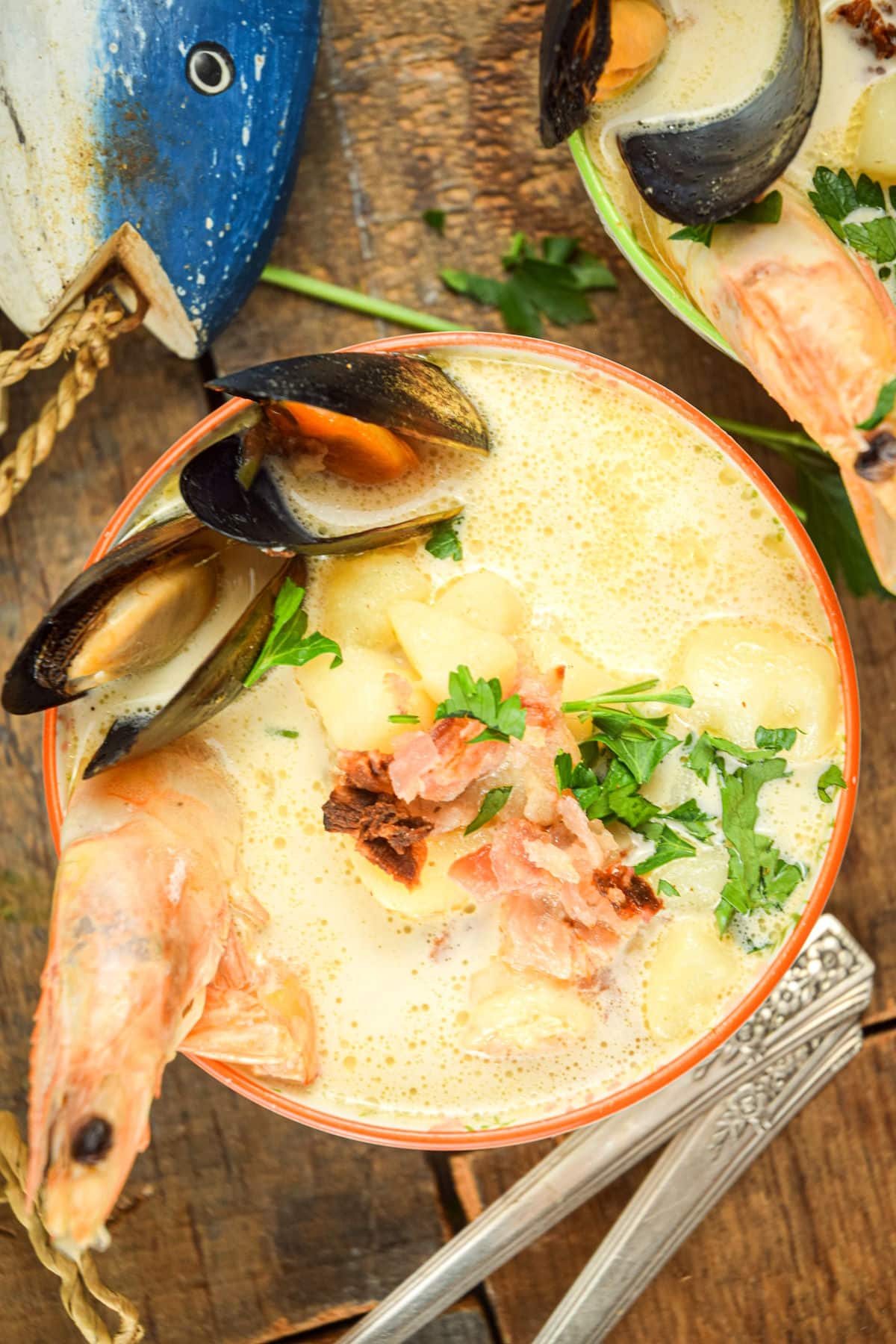 Seafood chowder in bowl on wooden background.