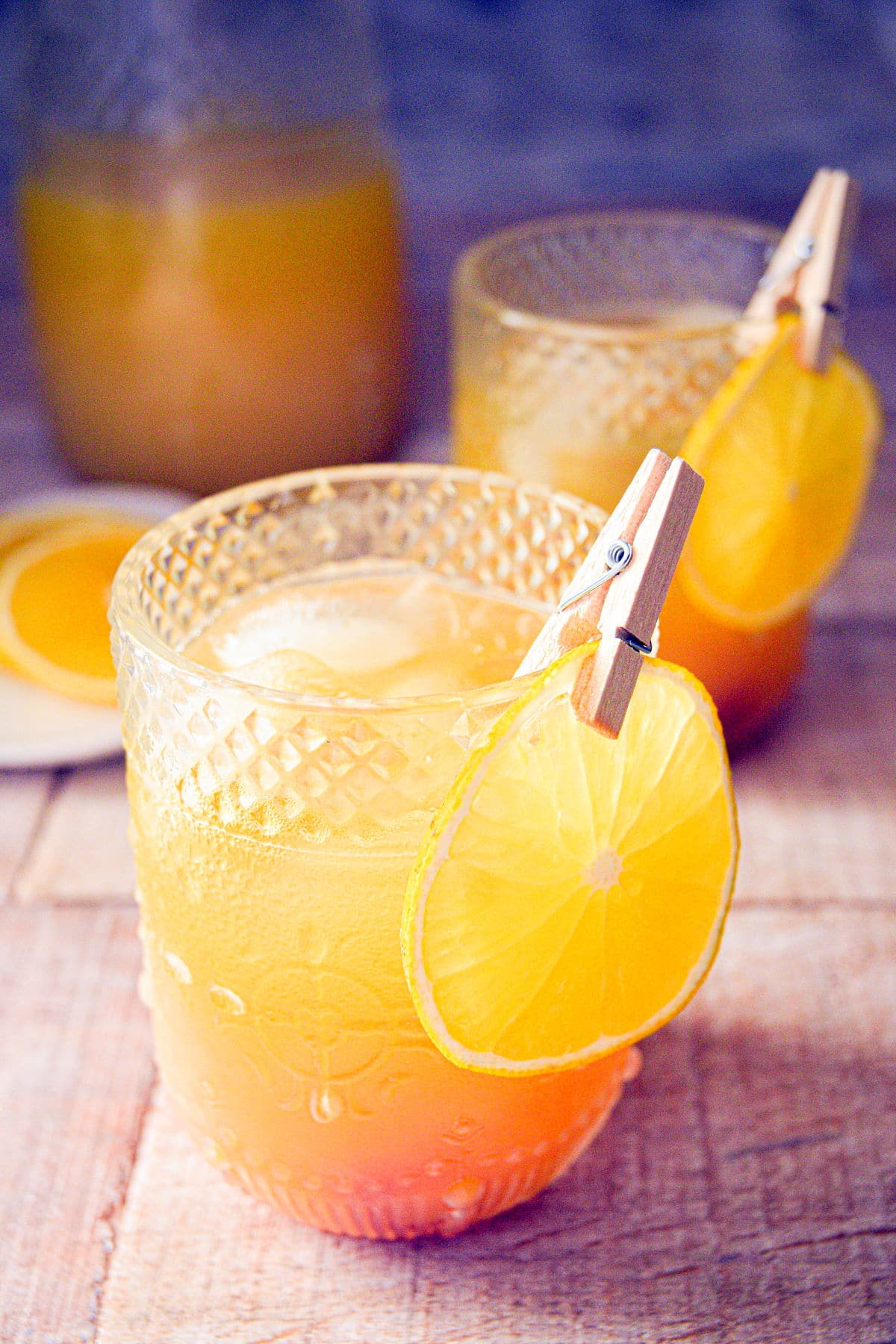 Pumpkin punch in a glass with a pitcher of punch in the background.
