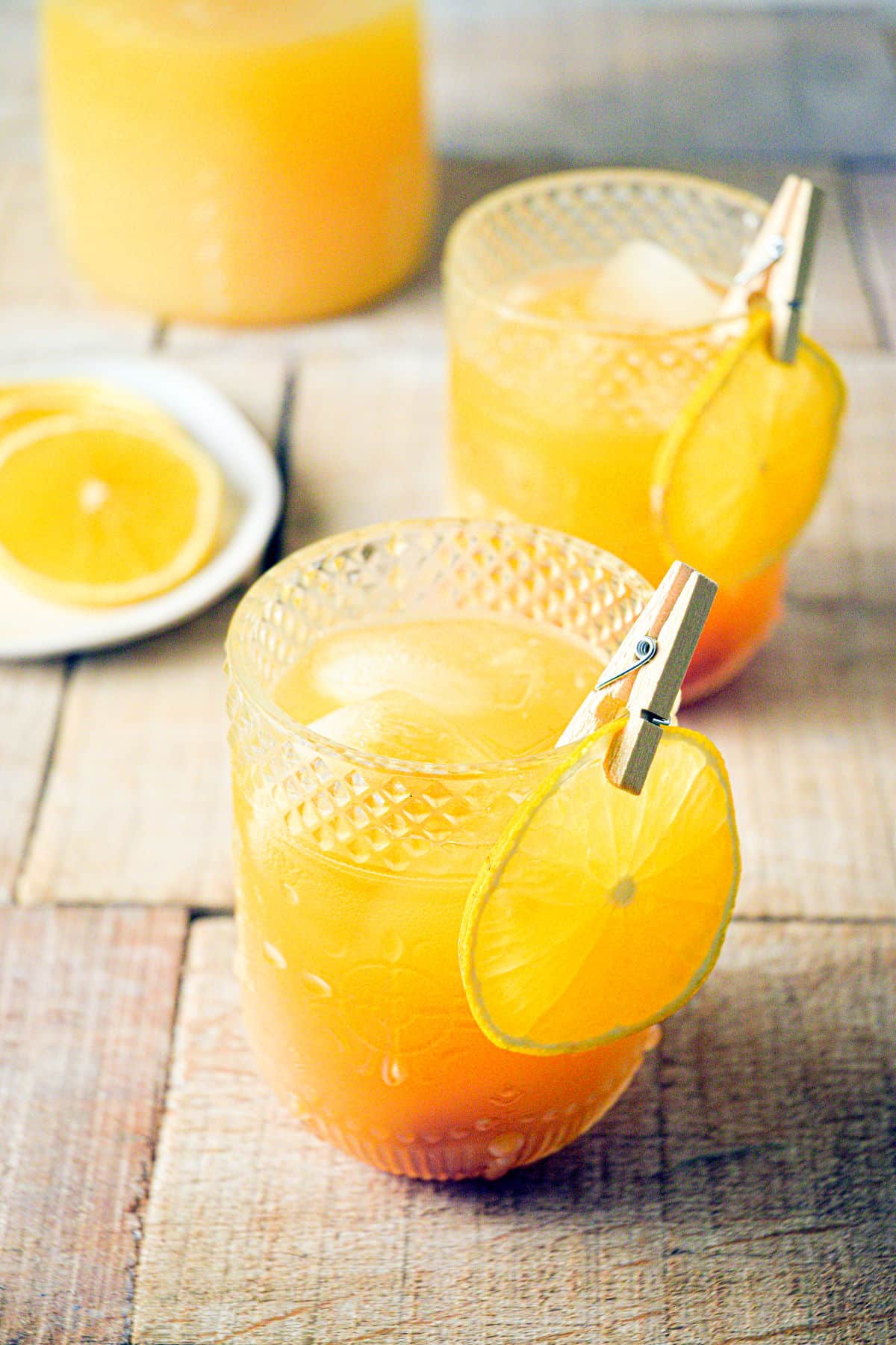 Pumpkin punch in glasses with orange slice garnish.