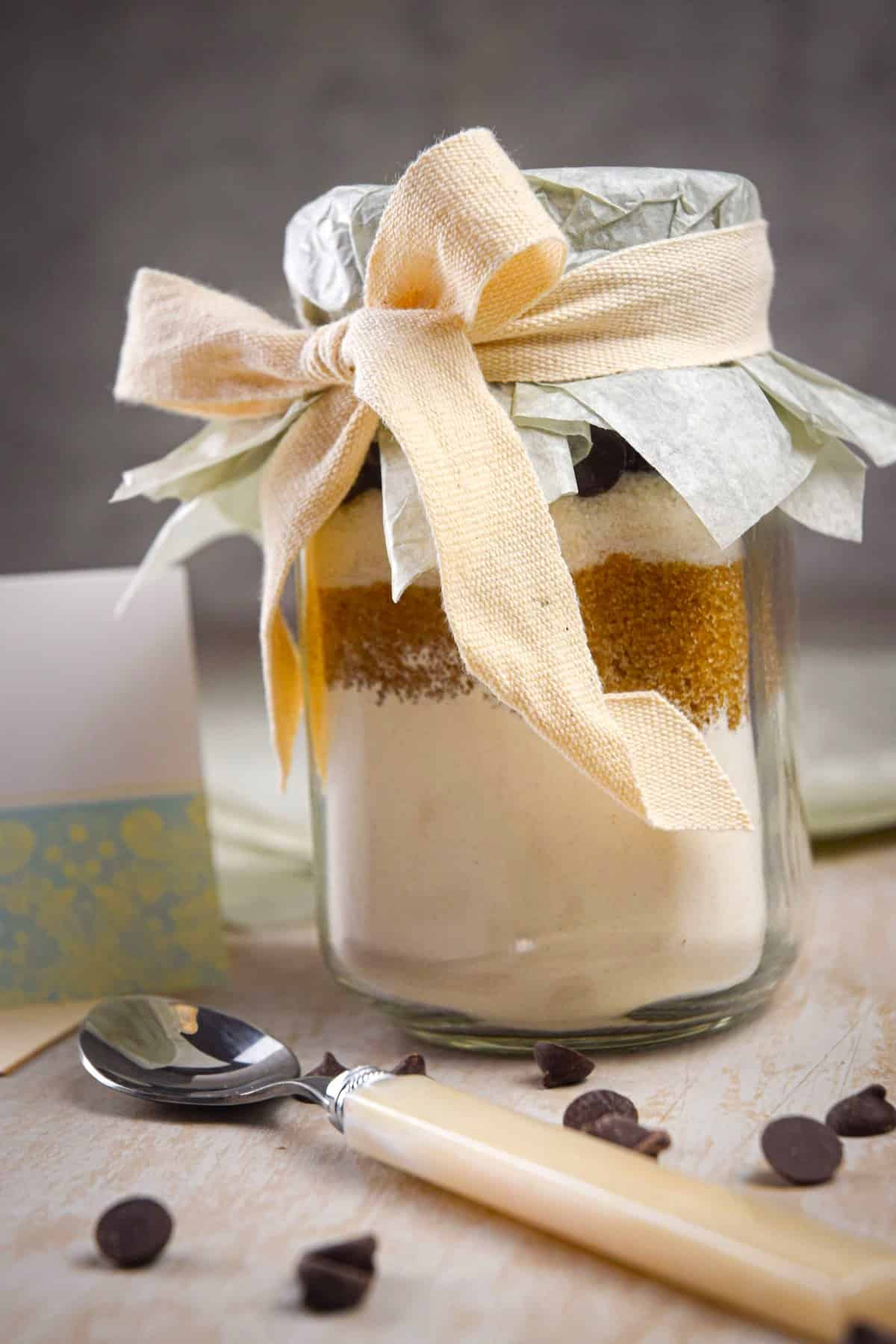 Chocolate chip cookie mix in jar with ribbon tied into a bow.