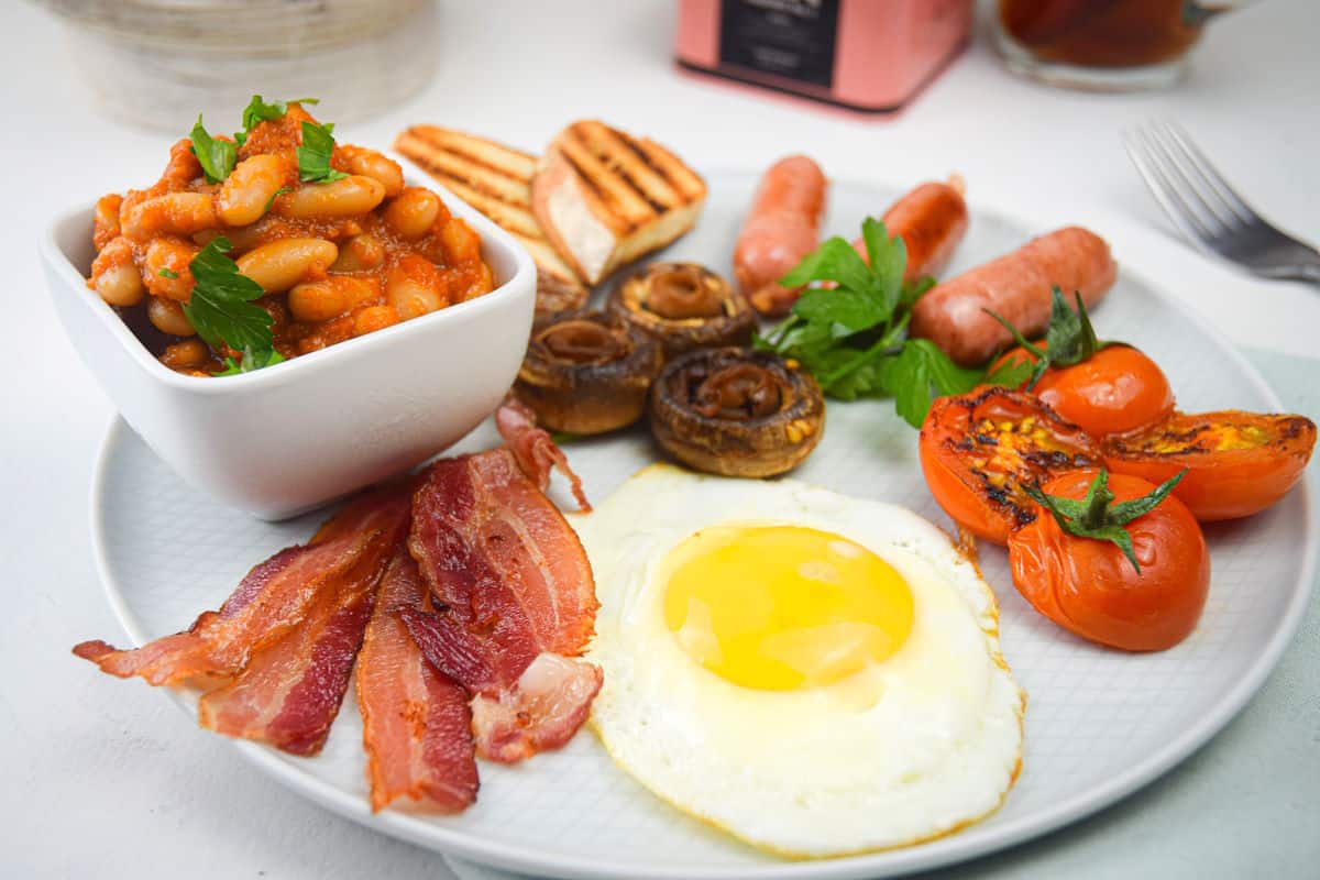 Full English breakfast on white plate.