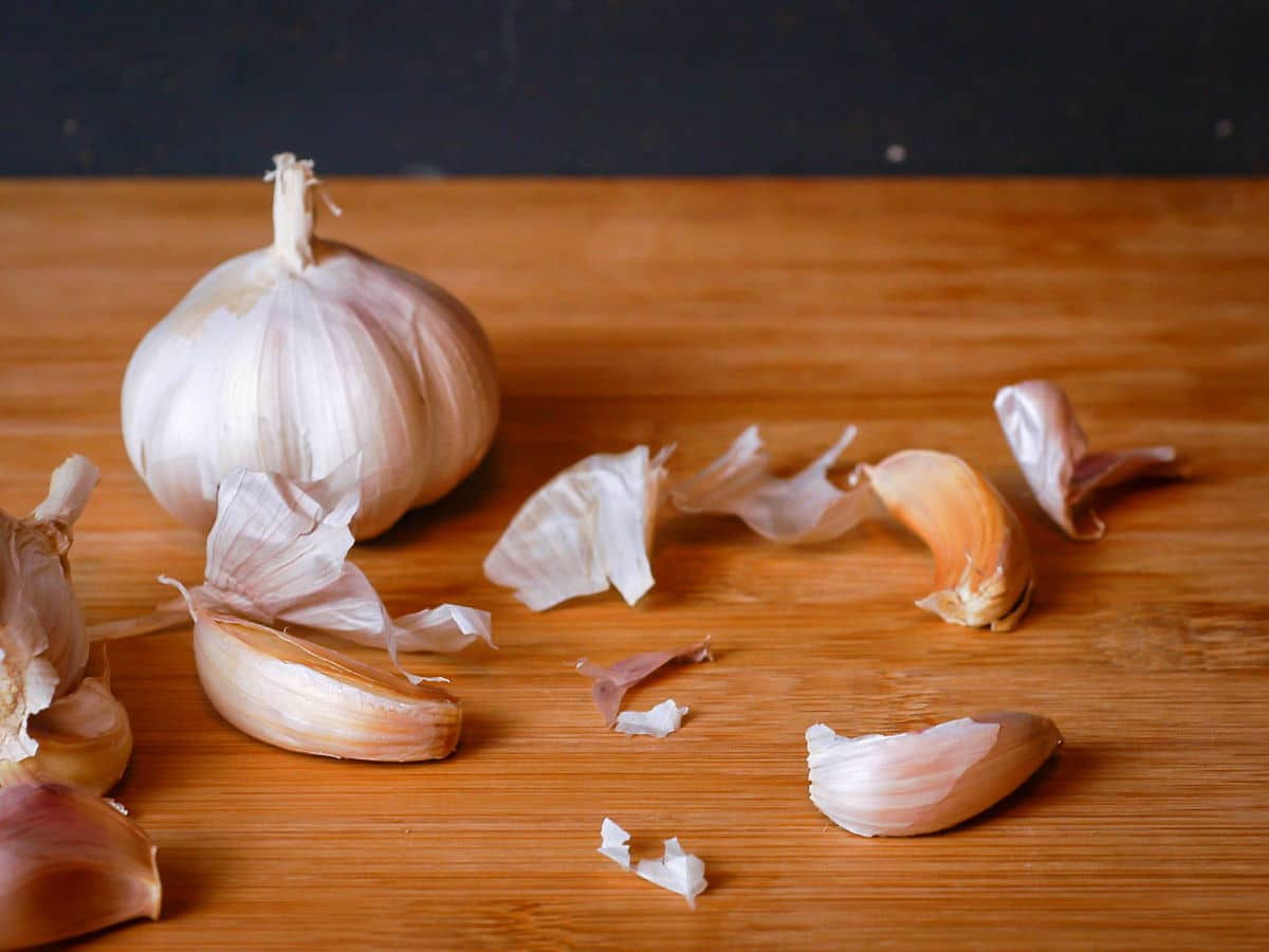 Garlic bulb and cloves on wooden table.