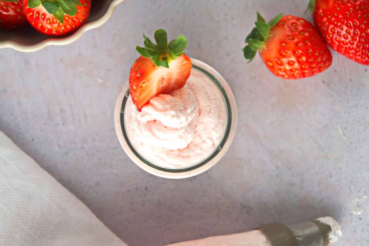 Grenadine whipped cream in a jar with fresh strawberries.