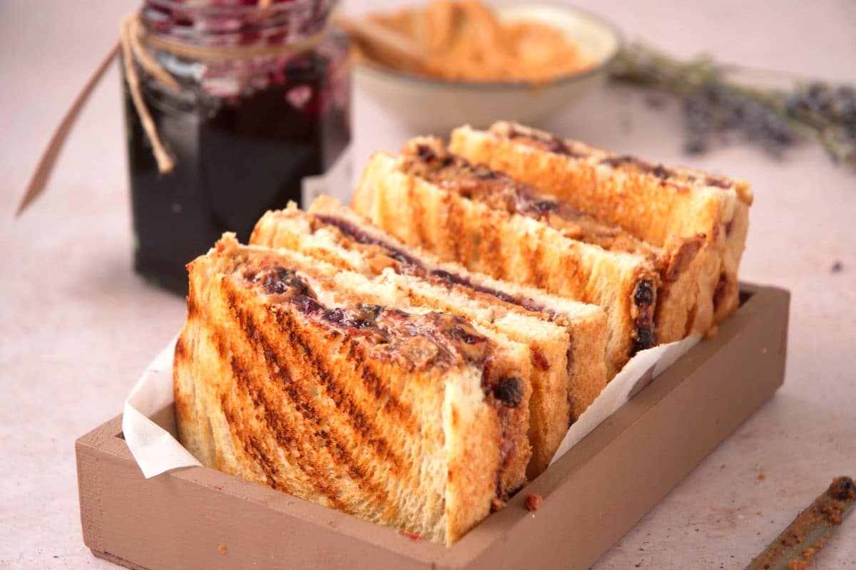 Grilled PBJ sandwiches in rectangular, wooden dish.