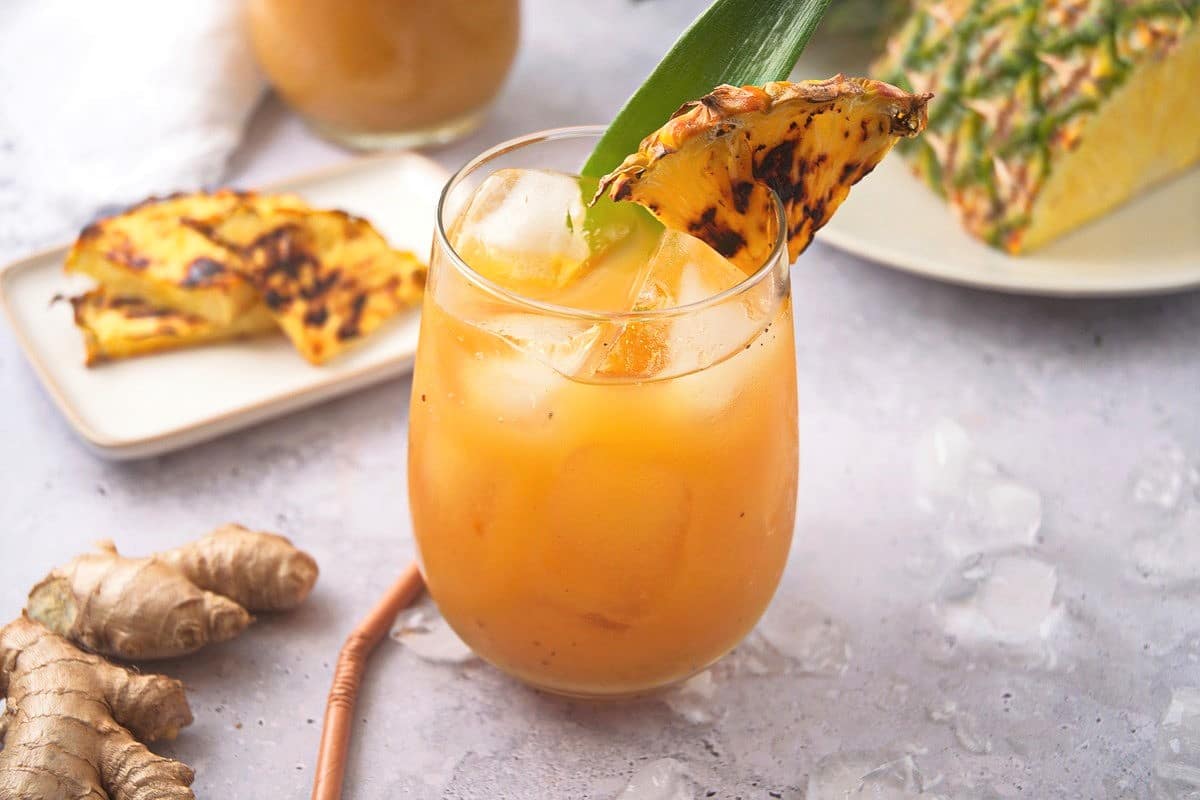 Grilled pineapple juice and wedge in glass.