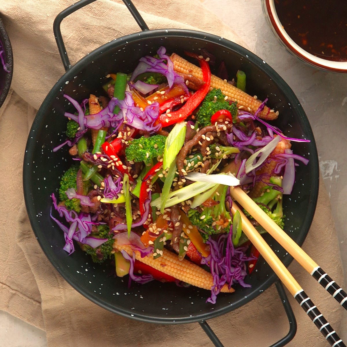 Ground beef stir fry with veggies in bowl with chopsticks.