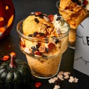 Halloween ice cream in glass ice cream dish with spooky candies and decor.