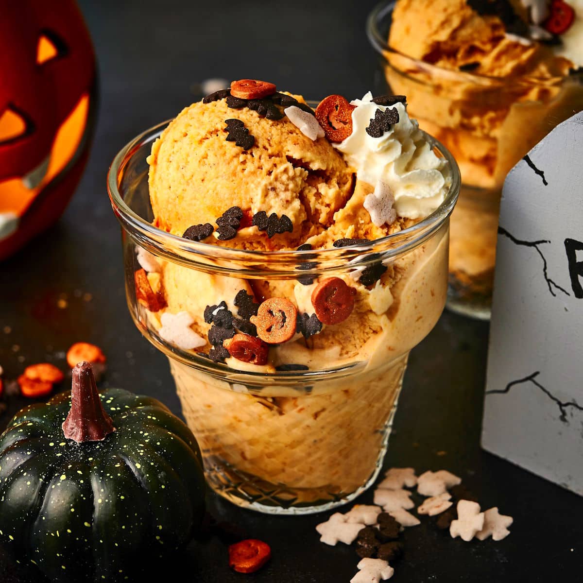 Halloween ice cream in glass ice cream dish with spooky candies and decor.