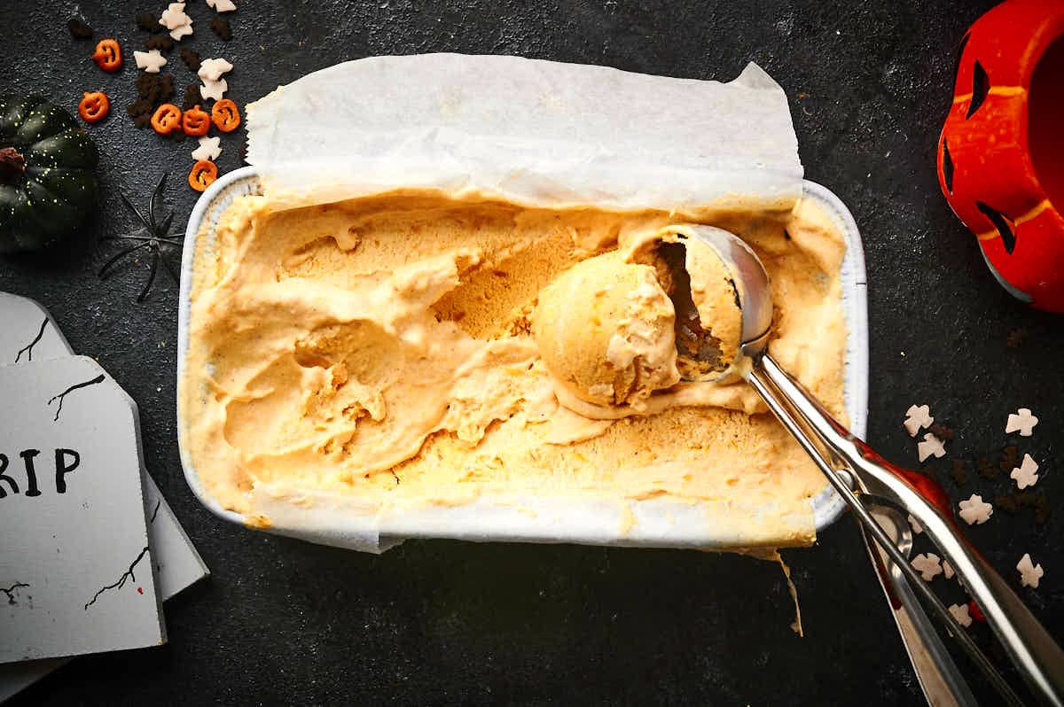 Halloween ice cream in loaf pan with ice cream scoop.