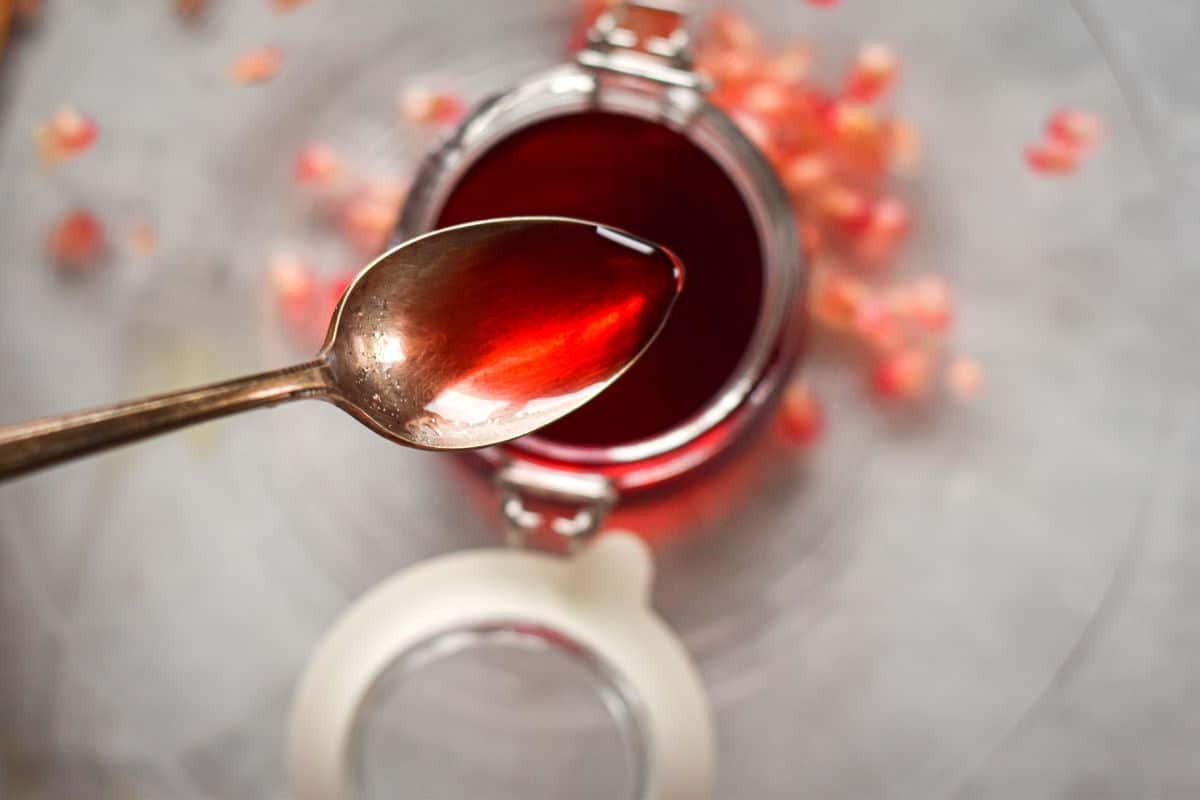 Homemade grenadine syrup in a spoon.