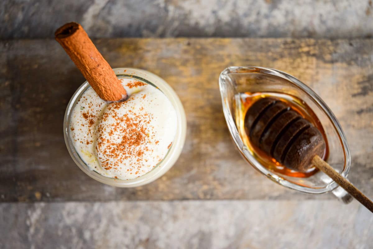 Whipped topping in a bowl with cinnamon and honey in a separate bowl.