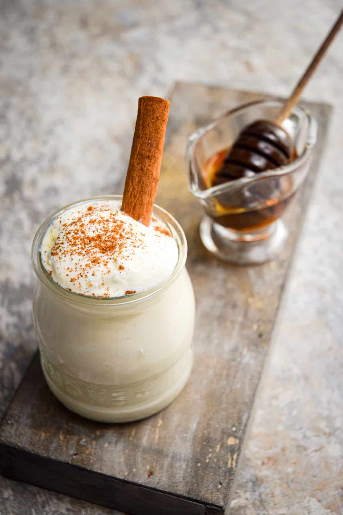 Homemade whipped topping with cinnamon and honey in small jar.