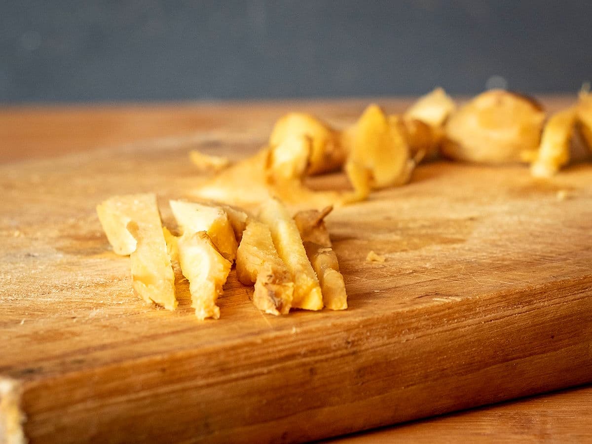 Ginger root strips on cutting board.
