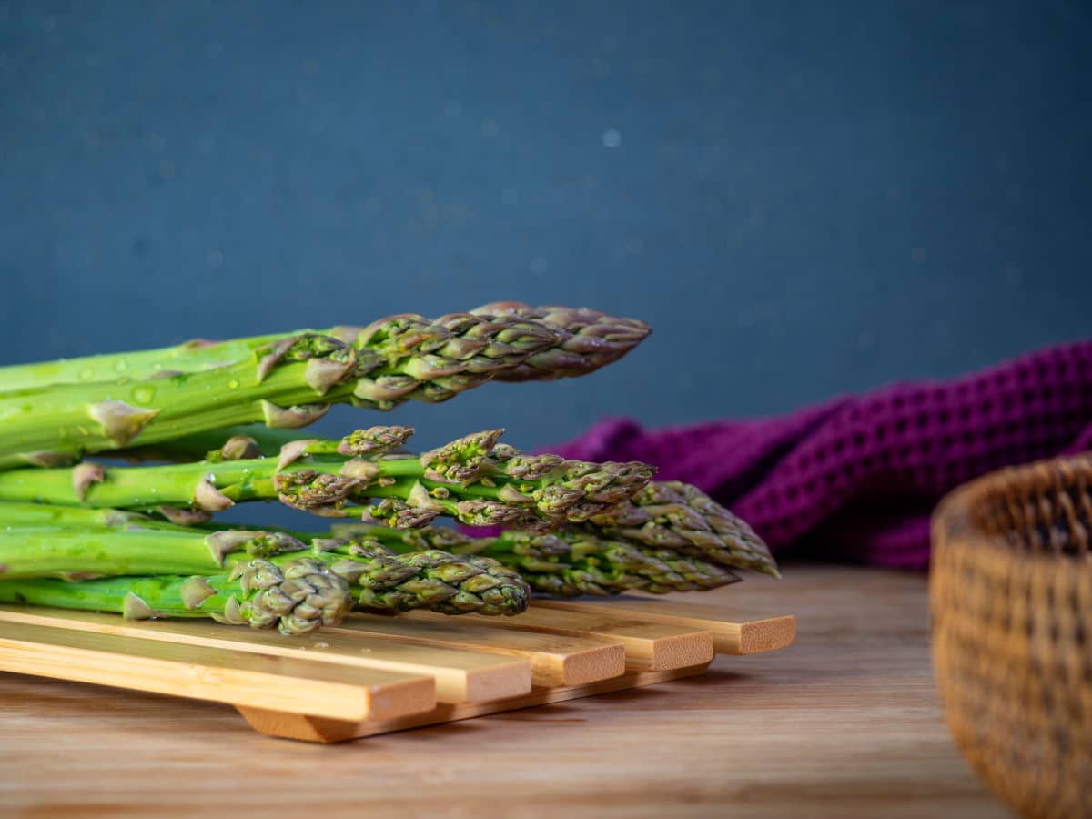 Fresh green asparagus on a wooden rack.