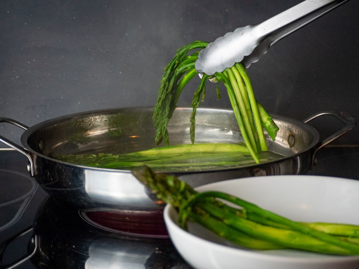 How to Cook Asparagus on the Stove - Step 6 Cooked asparagus in a pan with tongs.
