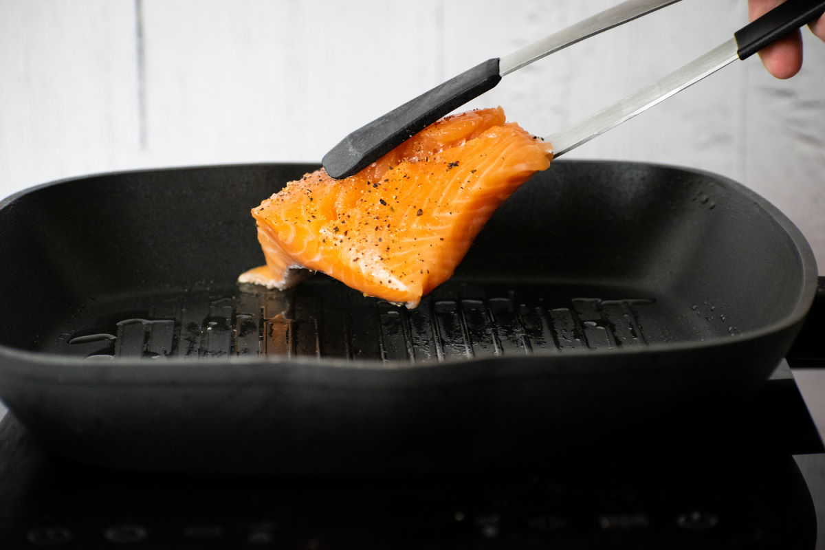 How to Cook Salmon With Skin Step 4 Salmon fillet in tongs over grill pan.