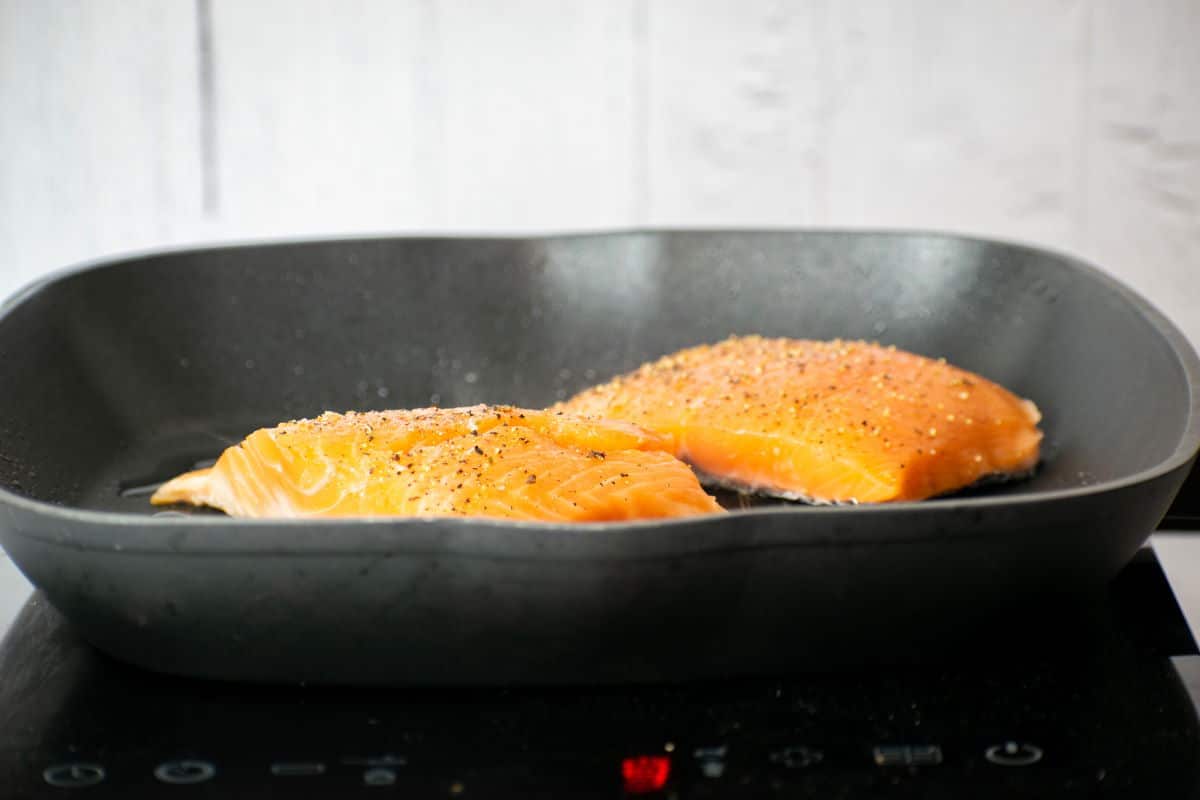 How to Cook Salmon With Skin Step 4-2 2 salmon fillets in pan, cooking.