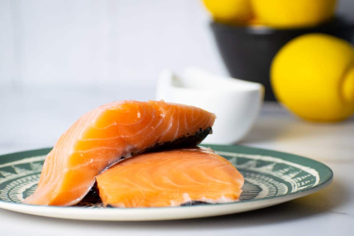 How to Cook Salmon With Skin_Prep Raw salmon steaks on a plate with the skin on.