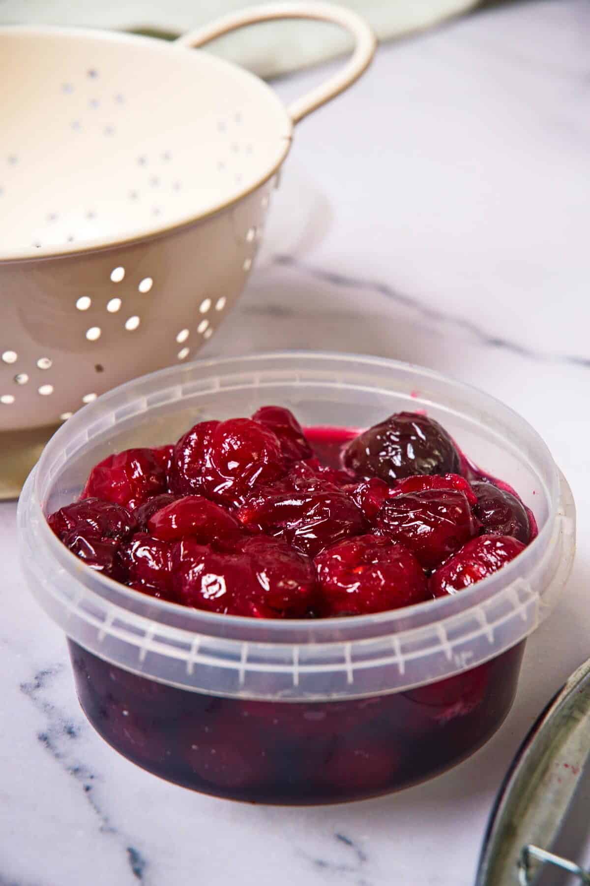 Cherries in a sugar syrup in plastic container.