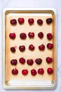 Pitted cherries on pan, top view.