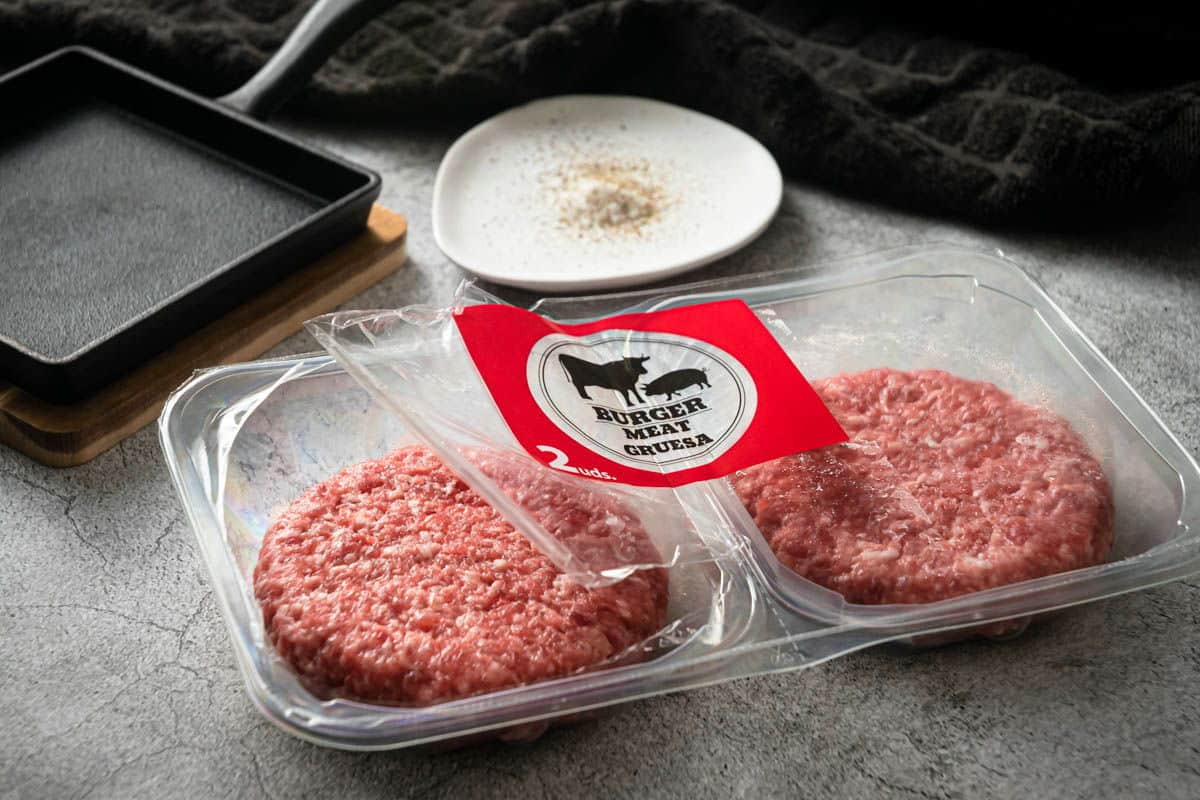 Raw frozen burger patties in a package.