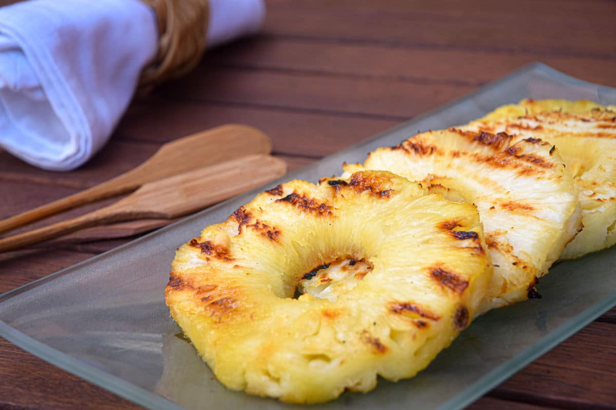 How to Grill Pineapple Slices_12 Grilled pineapple slices on glass serving dish.