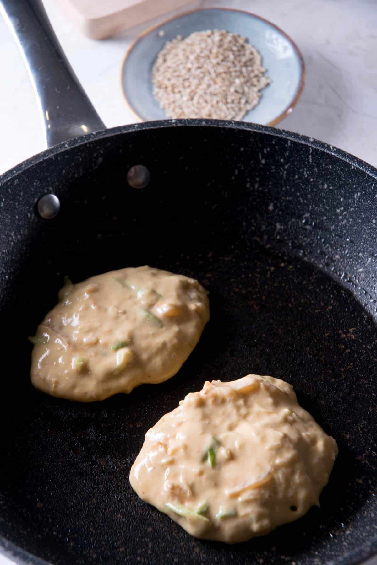 Kimchi pancake batter in a frying pan.