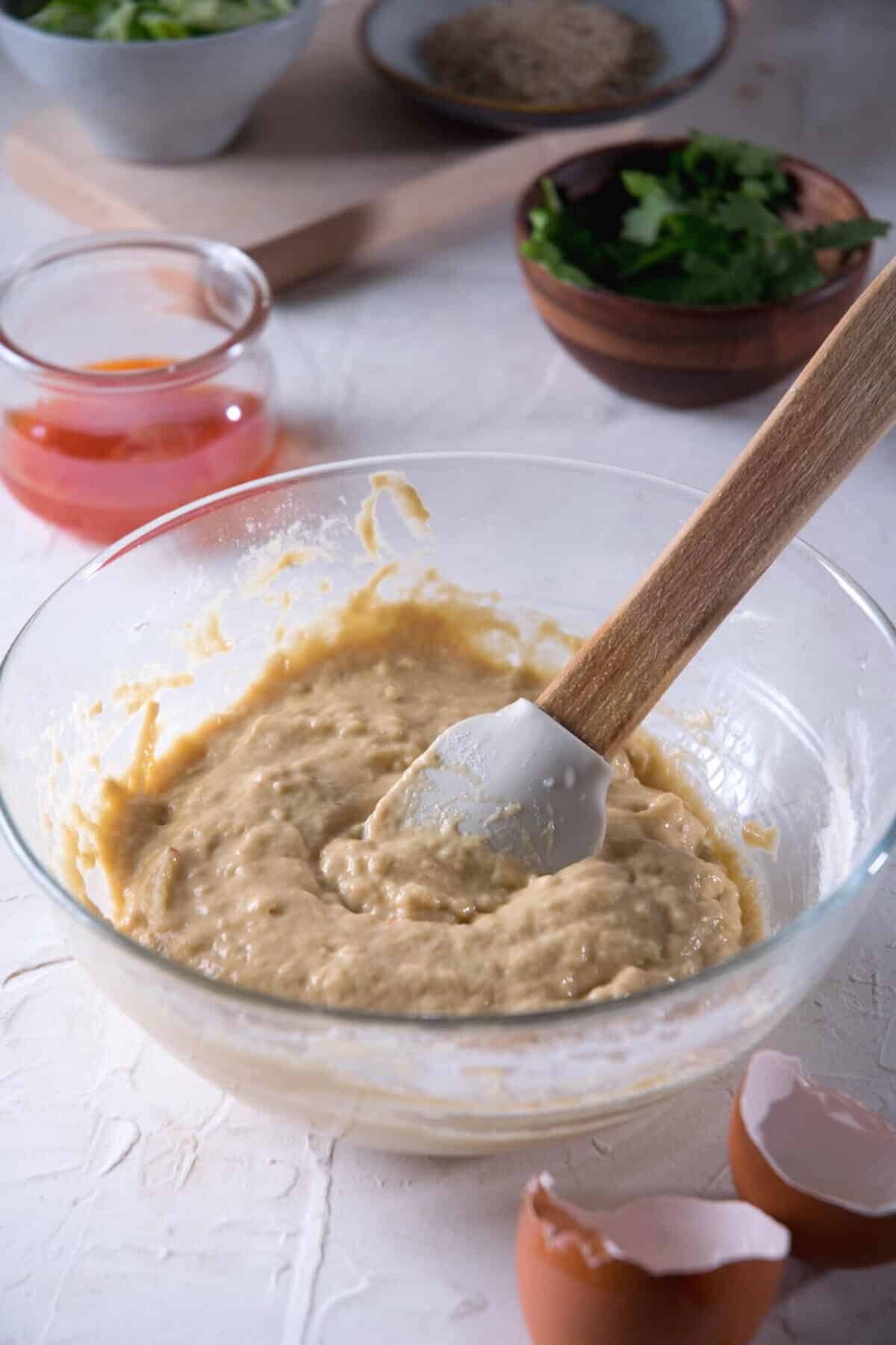 Kimchi pancake batter in a bowl with a spatula.