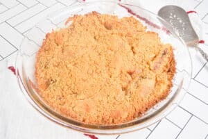 Baked, golden apple crisp in a pie dish.
