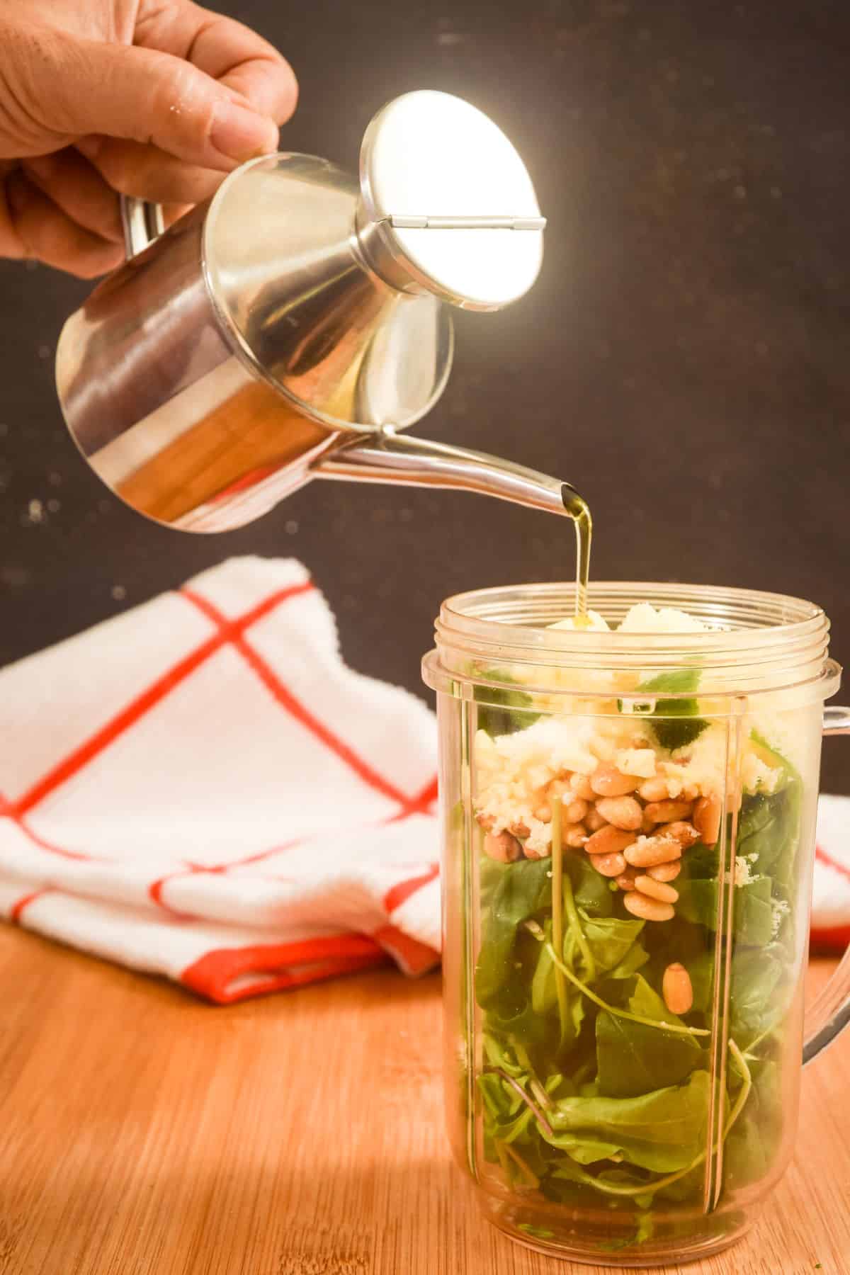 Basil pesto ingredients in a bullet blender jar.