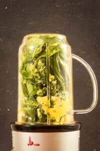Basil pesto ingredients in a bullet blender.
