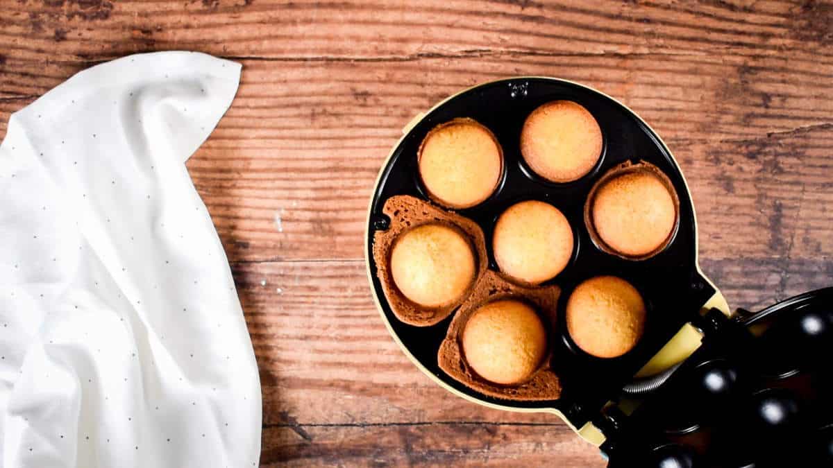 How to Make Cake Pops with a Cake Pop Maker Step 6 Baked cake balls in cake pop maker, wood background.