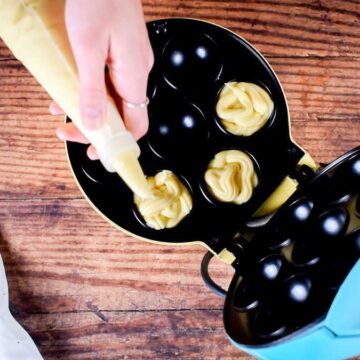 Piping batter into cake pop maker cavities.