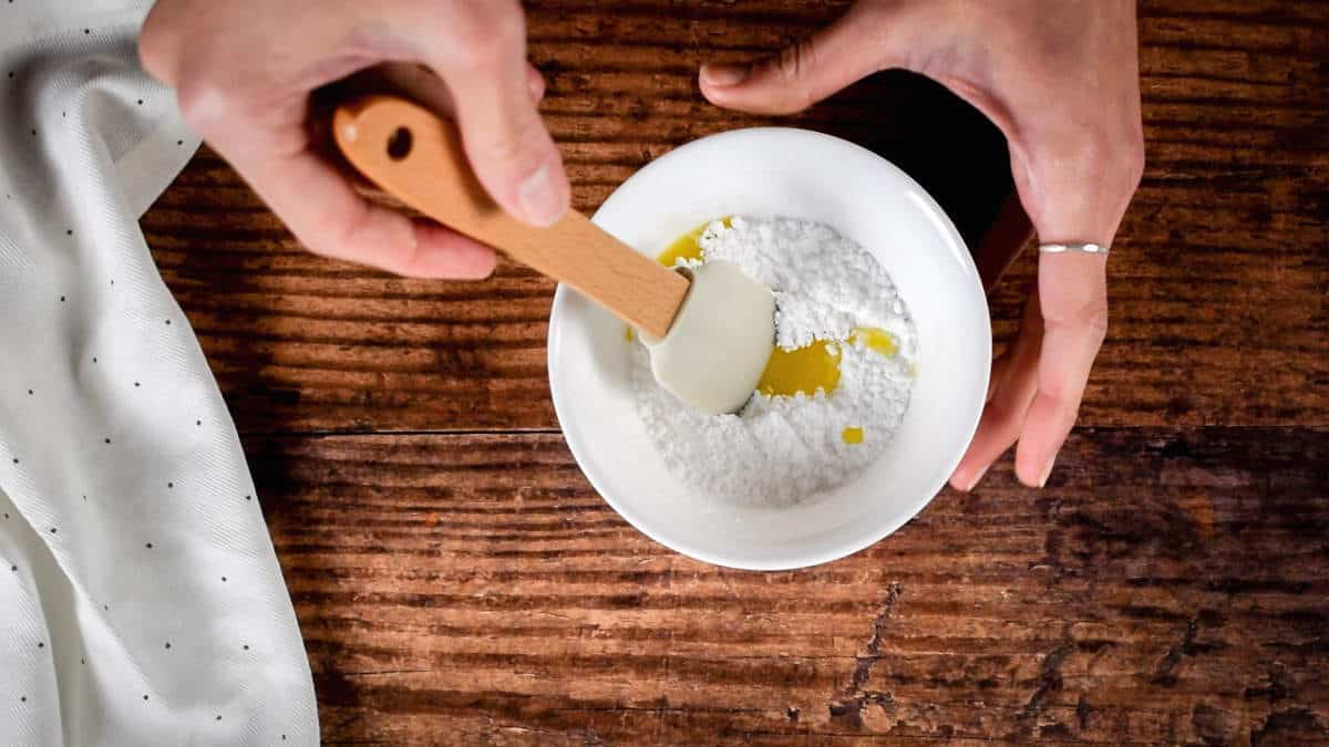 How to Make Cake Pops with a Cake Pop Maker Step 7-3 Adding orange juice to icing sugar in a bowl.