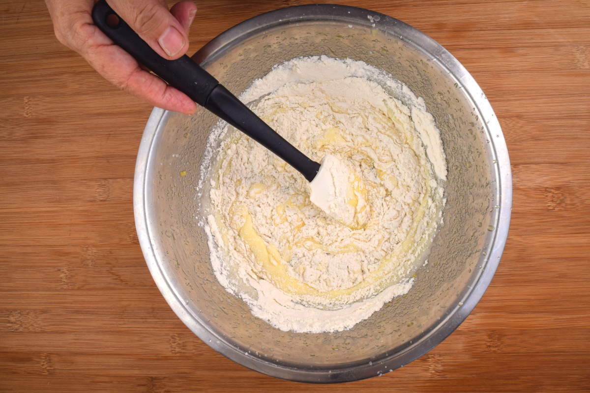 How to Make Cake Pops with a Mold Step 4 Cake pop batter and spatula in metal bowl, wooden background.