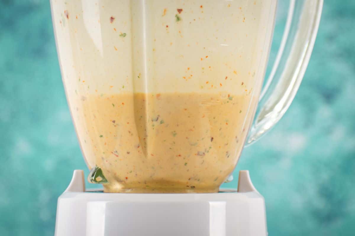How to make chipotle sauce Step 2-7 Chipotle sauce in a blender on blue background.