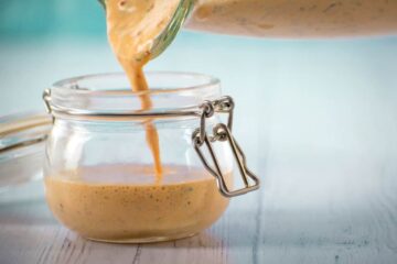 Chipotle sauce in a jar on blue background.