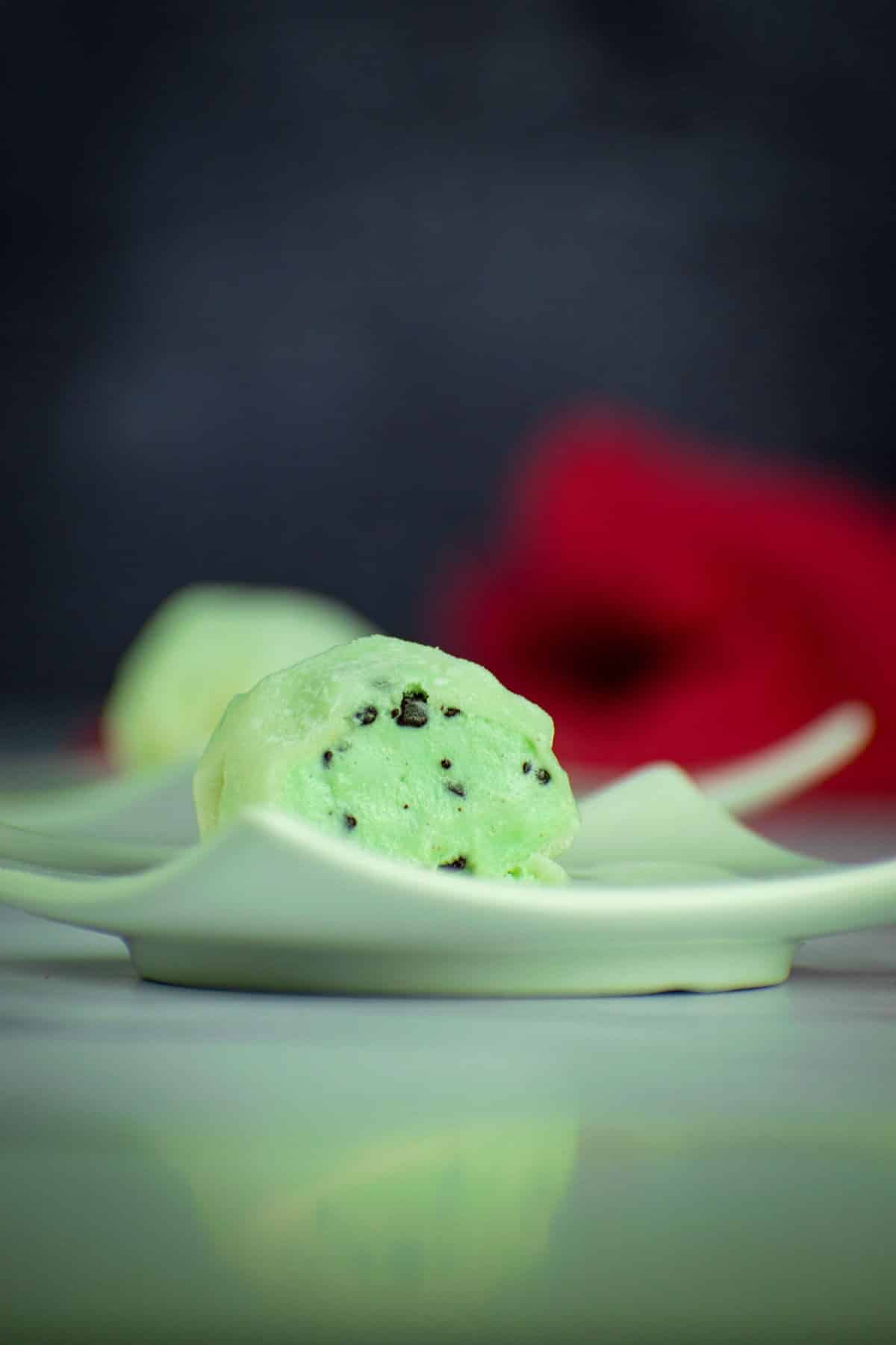 How to Make Mochi Ice Cream Step 9-3 Mochi ball with mint chocolate chip ice cream cut open on small plate.